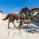 statue of a mare and foal playing for outdoor