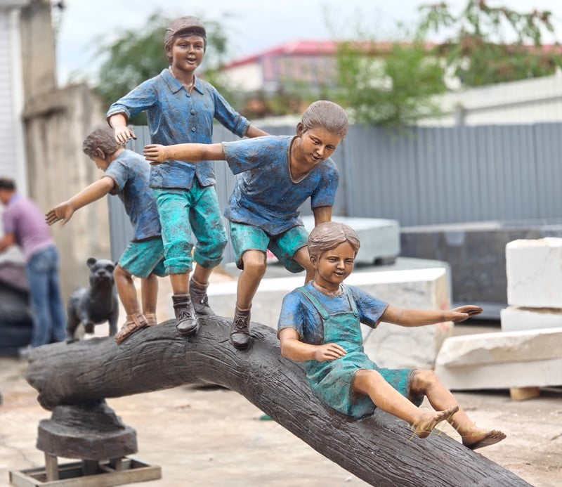 hree boys and a girl playing on a tree stump