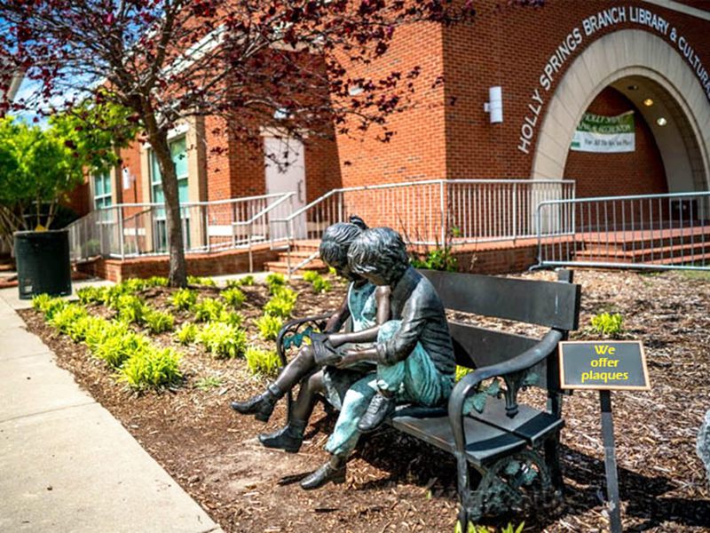 bronze-statue-boy-and-girl-sitting-on-bench-reading-book