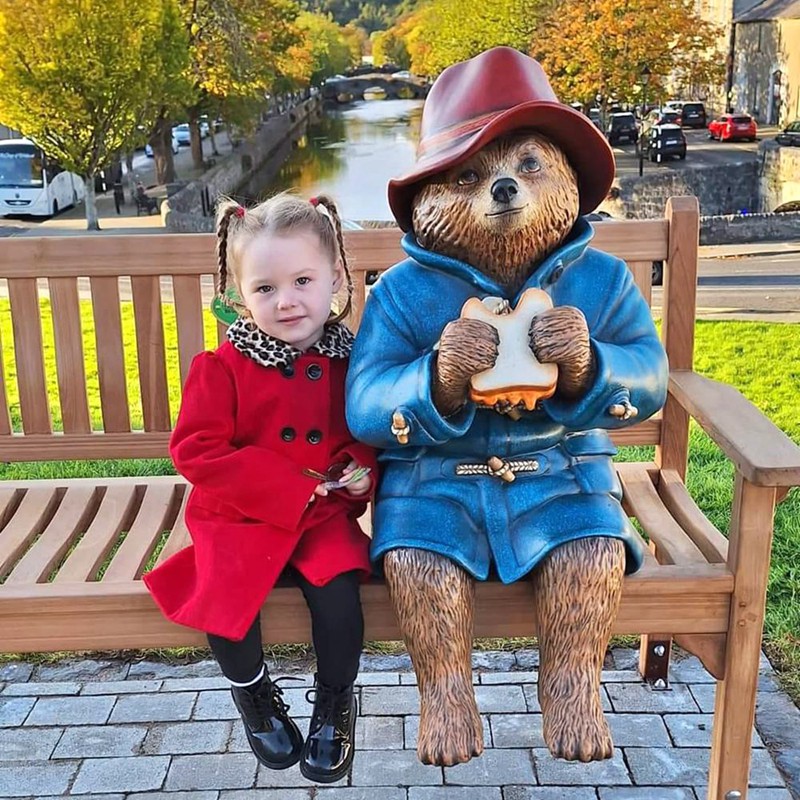 blue paddington bear statue with girl
