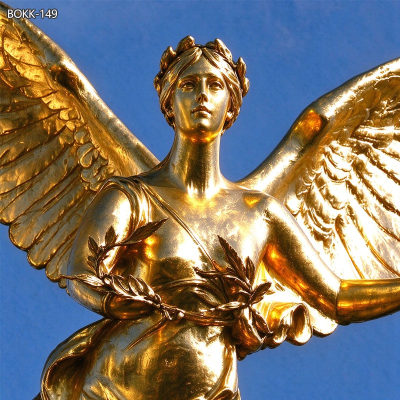 Close-up of golden bronze angel statue facial and wreath details