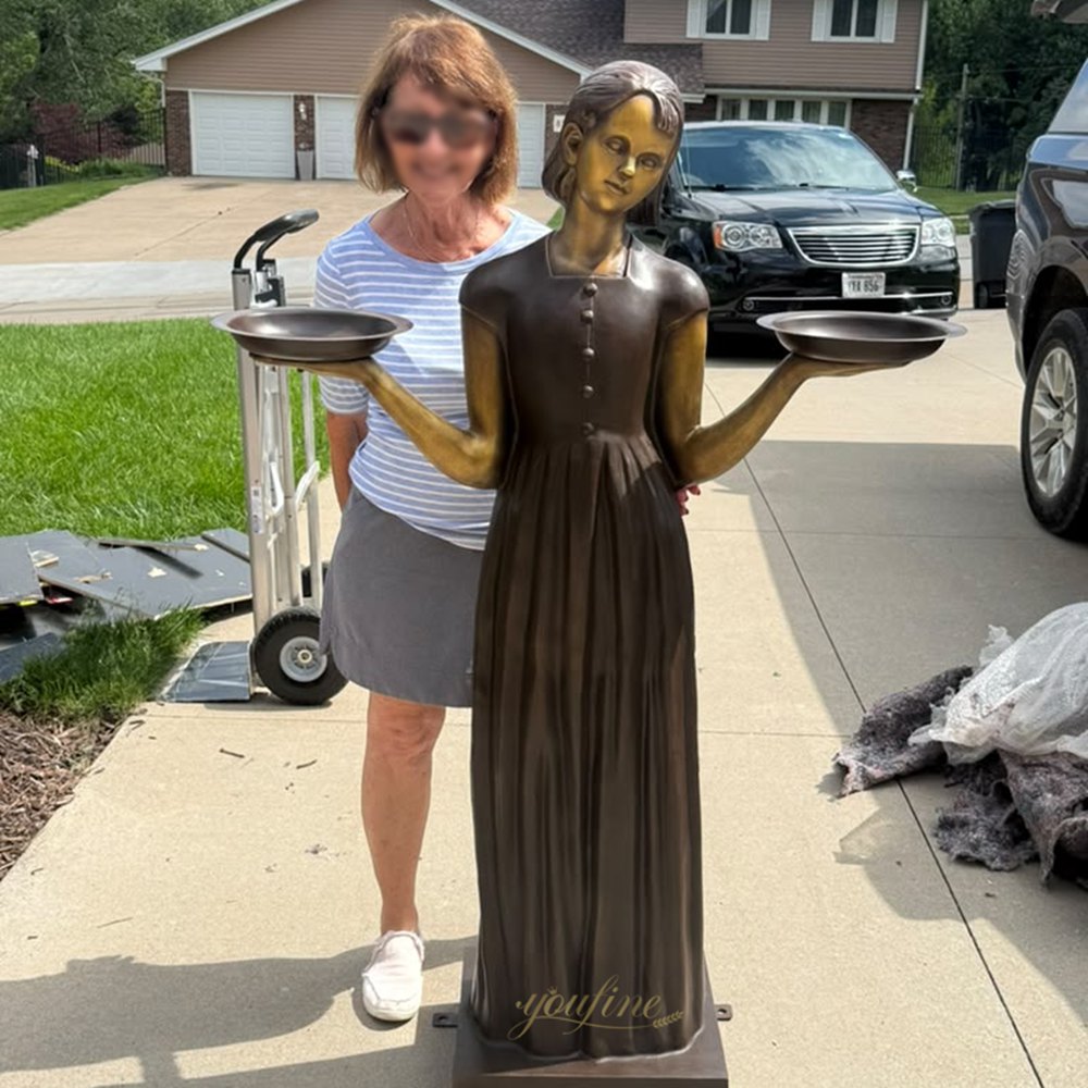 A customer receives the bronze Savannah Bird Girl Statue