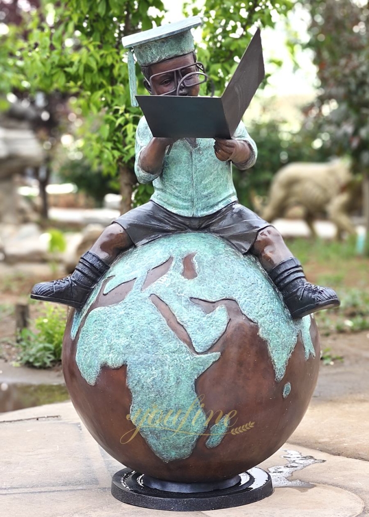Sculpture of a child sitting on the earth and reading