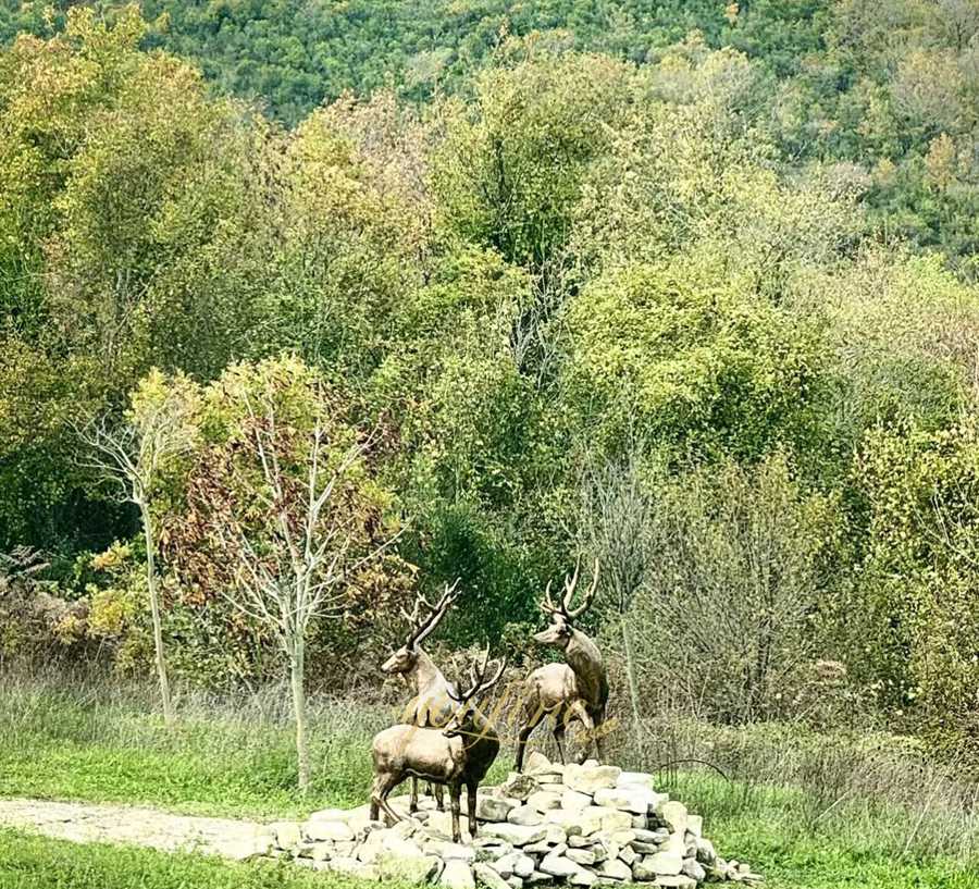 Three elk sculptures standing on the rocks