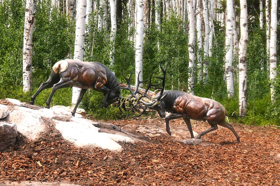 Two fighting elk sculptures