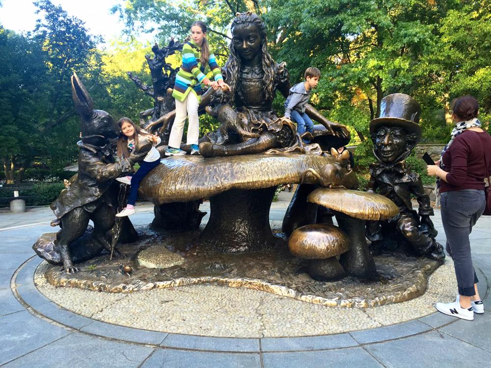 Top 10 Most Popular Bronze Sculptures in Central Park - Blog - 3 Children play on alice in wonderland famous statue
