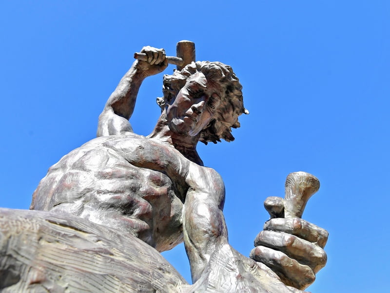 Self Made Man bronze statue -- a man pulling himself up from the ground, symbolizing ambition and perseverance