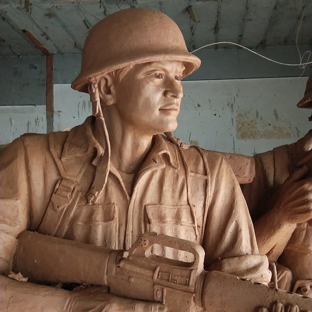 Clay model of a military sculpture featuring a figure holding a gun.