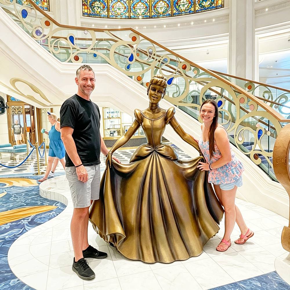 Tourists Taking Pictures With Life‑Size Bronze Cinderella Cruise Statue