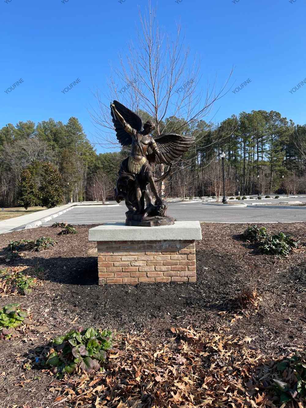 Bronze Saint Michael angel statue installed on a stone pedestal